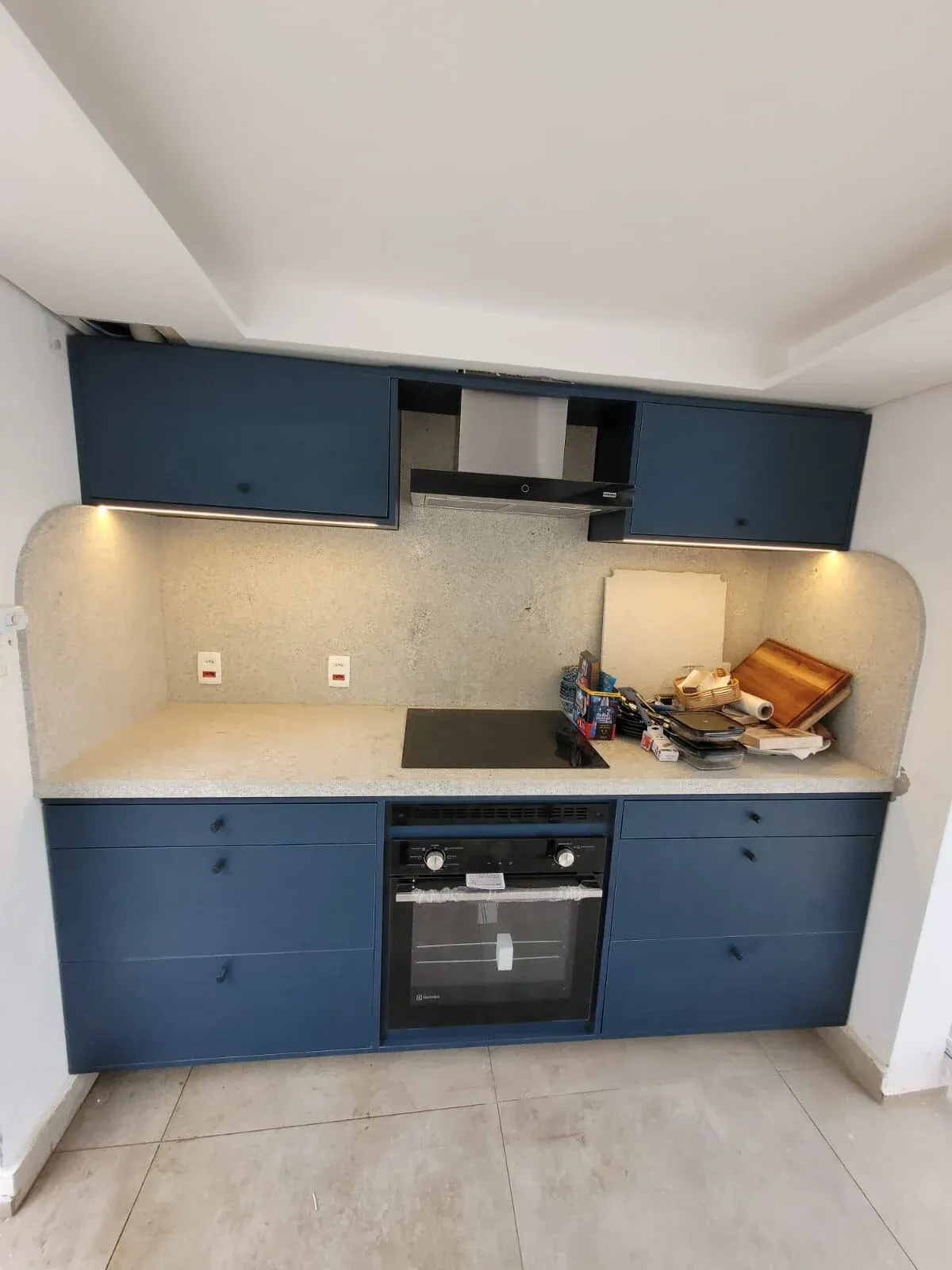 Cozinha planejada em azul fosco com bancada em granilite