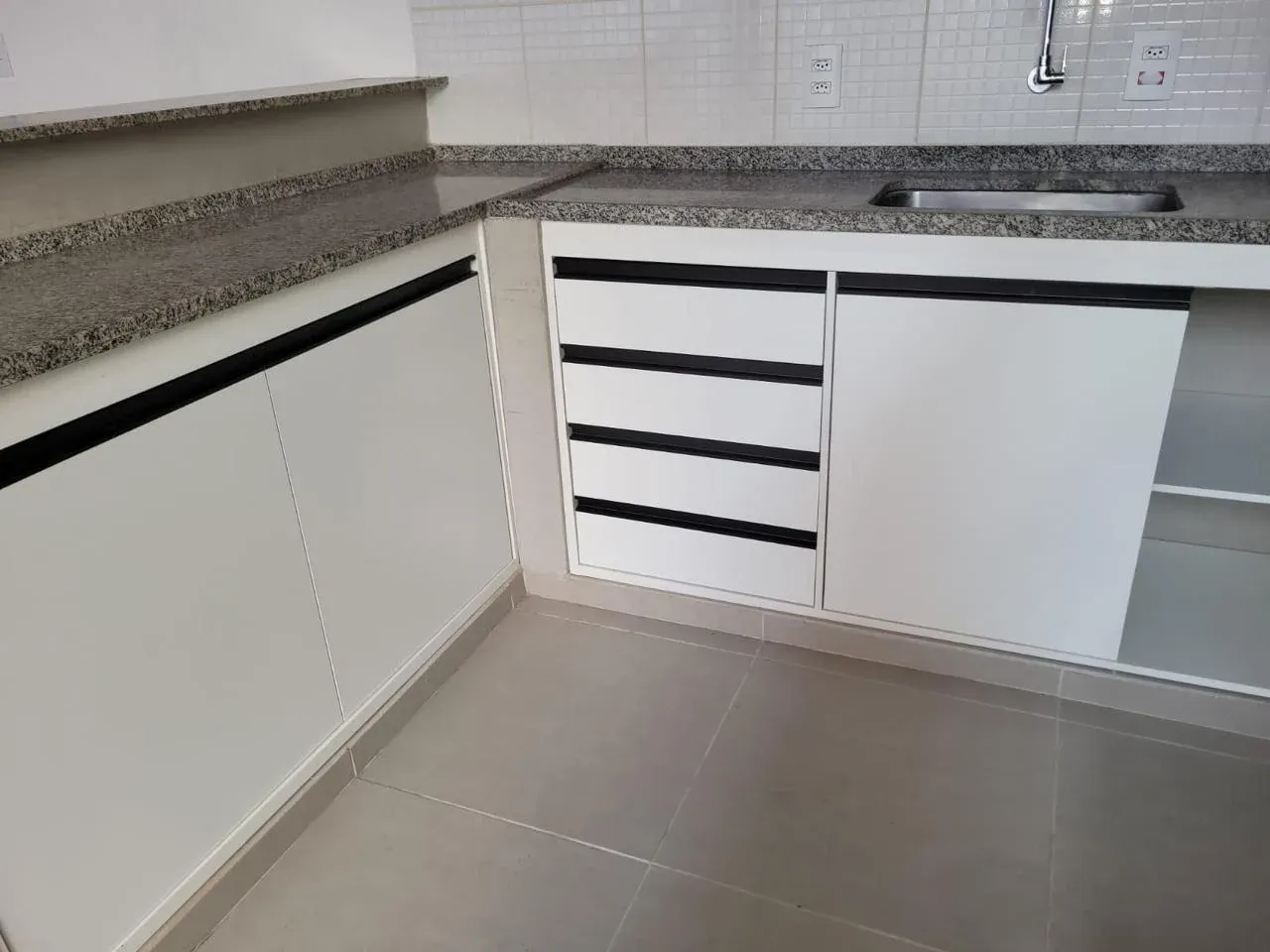 Detalhe de gaveteiro em MDF branco com puxadores gola pretos em área gourmet