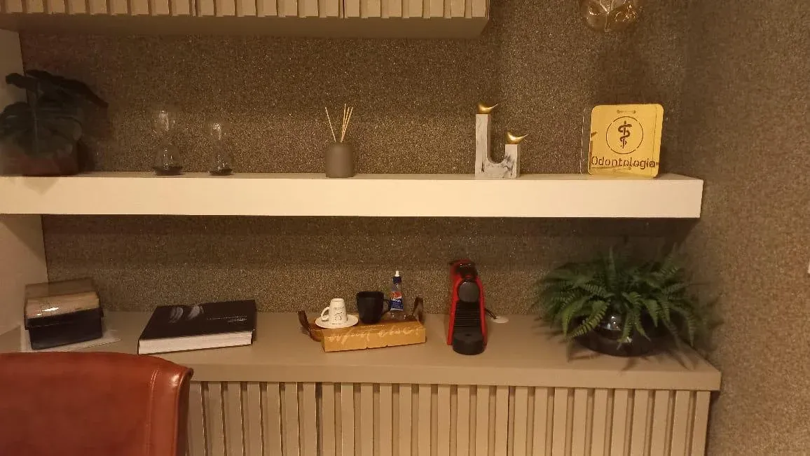 Cantinho do café planejado em consultório com buffet ripado cinza e prateleira decorativa